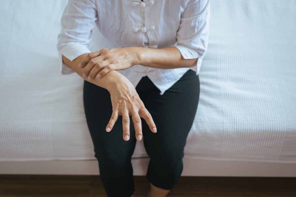 Elderly woman suffering with parkinson's disease symptoms