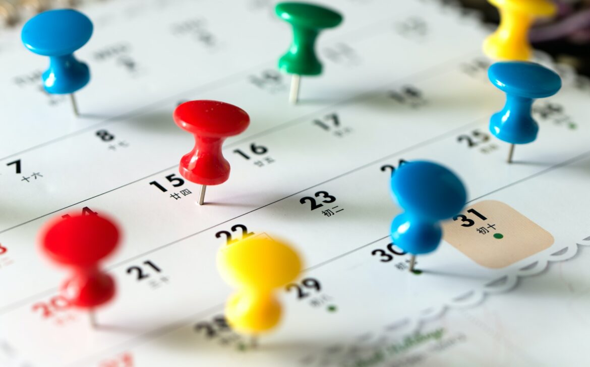 Thumb tack pins on calendar as reminder
