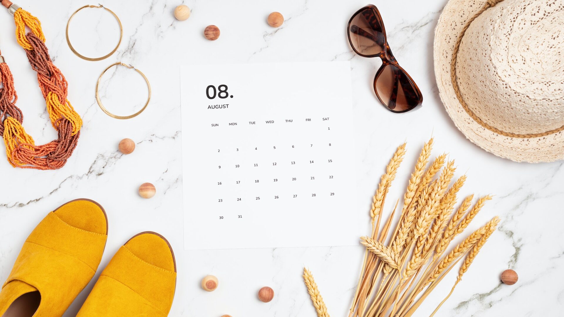 Flat lay with calendar for August with summer holidays fashion accessories