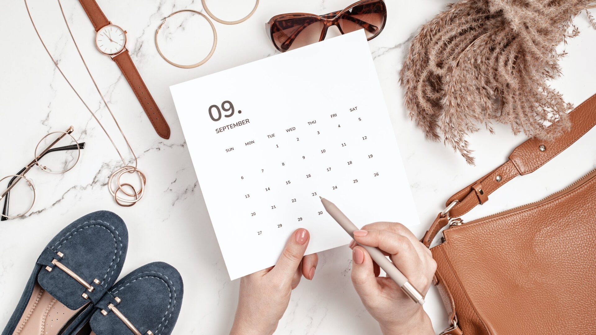 Flat lay with calendar for September with woman fashion fall accessories